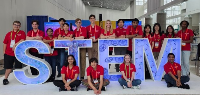 Picture of Team Alabama High School Students at a STEM sign at ISEF 2024