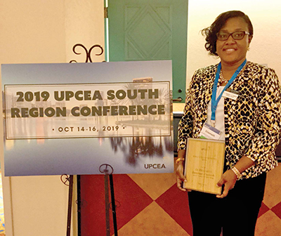 Elizabeth Essamuah-Quansah holding award at conference