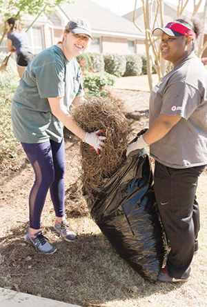 Two girls bag pinestraw during service activity