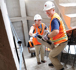 Scott Kramer carrying cinder blocks upstairs.