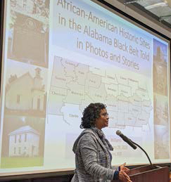 Woman speaks at podium during presentation