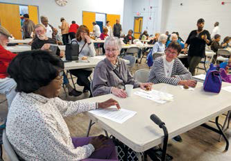 People sitting around table chatting at community center