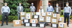 Group photo of people standing outside hospital donating supplies