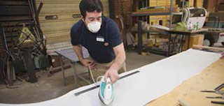 Man using iron on fabric