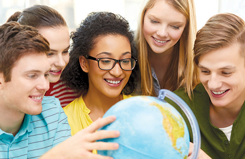 Group of young adults looking at globe