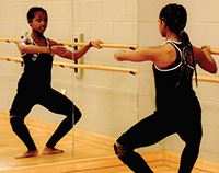 Girl practices dance poses in mirror