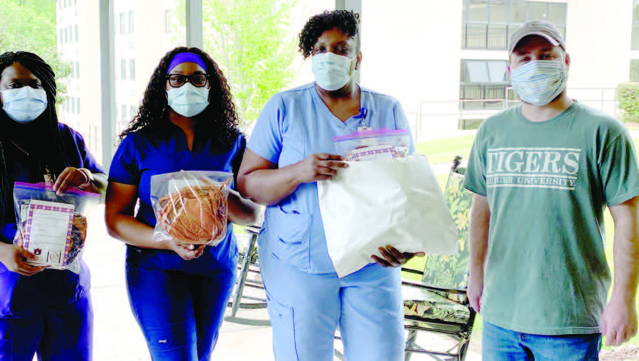 Group of people holding bag of face masks that were donated