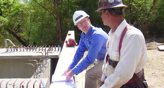 Two men in hard hats discuss