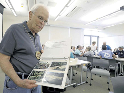 Photo of David Newton flipping through a photo album