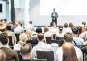 person lecturing a group of people in the audience