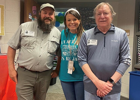 Amber Broadhead poses with herpetologist Jimmy Stiles and Roger Reid, writer for the Alabama Museum of Natural History, on Alabama Day. 