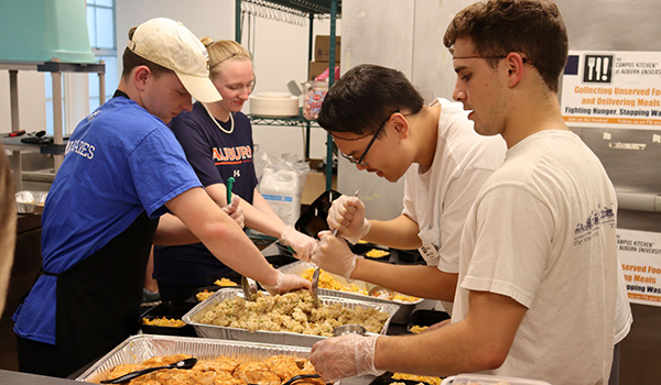 Auburn students, from left, Matt Tompson, Manie Castagneto, Michael Chen and Nick Martin work to package meals for The Campus Kitchen.